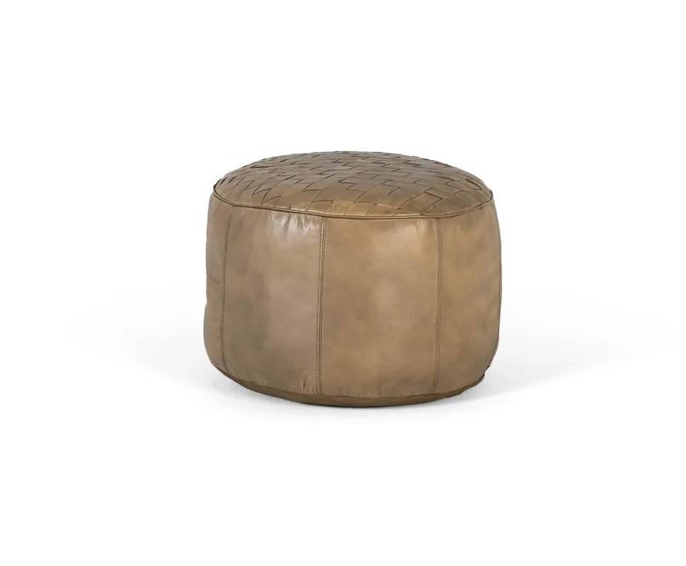 Este puff redondo esta confeccionado en piel de color beige, lo que le otorga un aspecto suave y elegante. La parte superior del puff está decorada con tiras entrelazadas de piel, las cuales se encuentran cosidas de forma ordenada y precisa. - Sofás sillones puffs